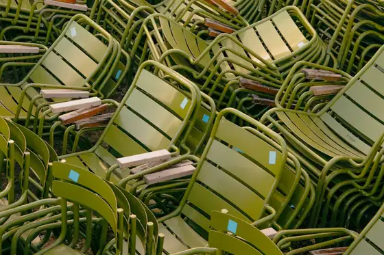 Dozens of identical chairs stacked in a warehouse