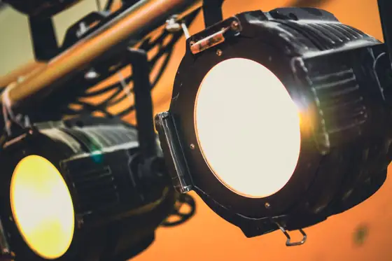 Two stage spotlights against an orange background